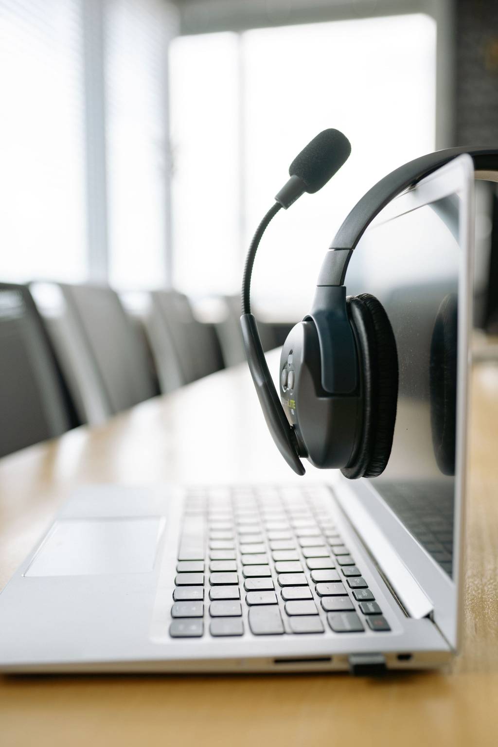 Headset op een laptop in een lichte kantooromgeving.