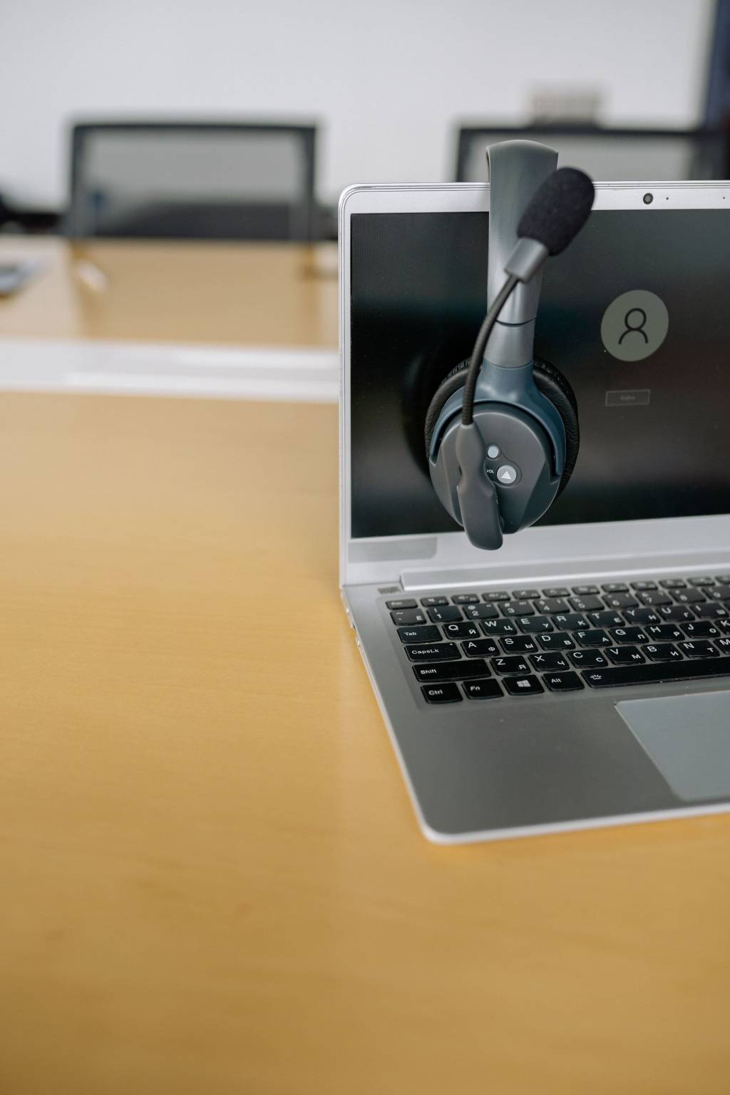 Laptop met headset op een bureau, klaar voor ondersteuning of telefonie.