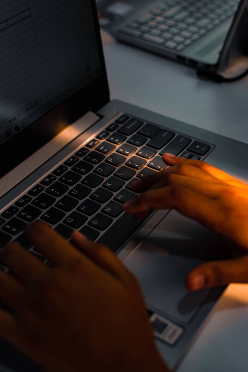 Handen typen op een laptop tijdens digitaal werk of ondersteuning op afstand.